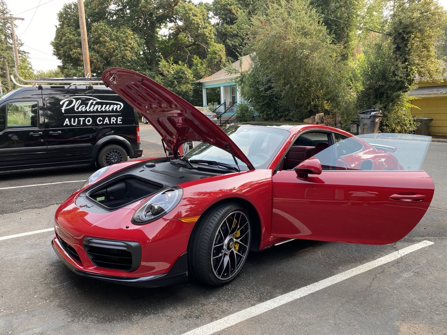 Red Porsche beside a Platinum Auto Care mobile detailing van