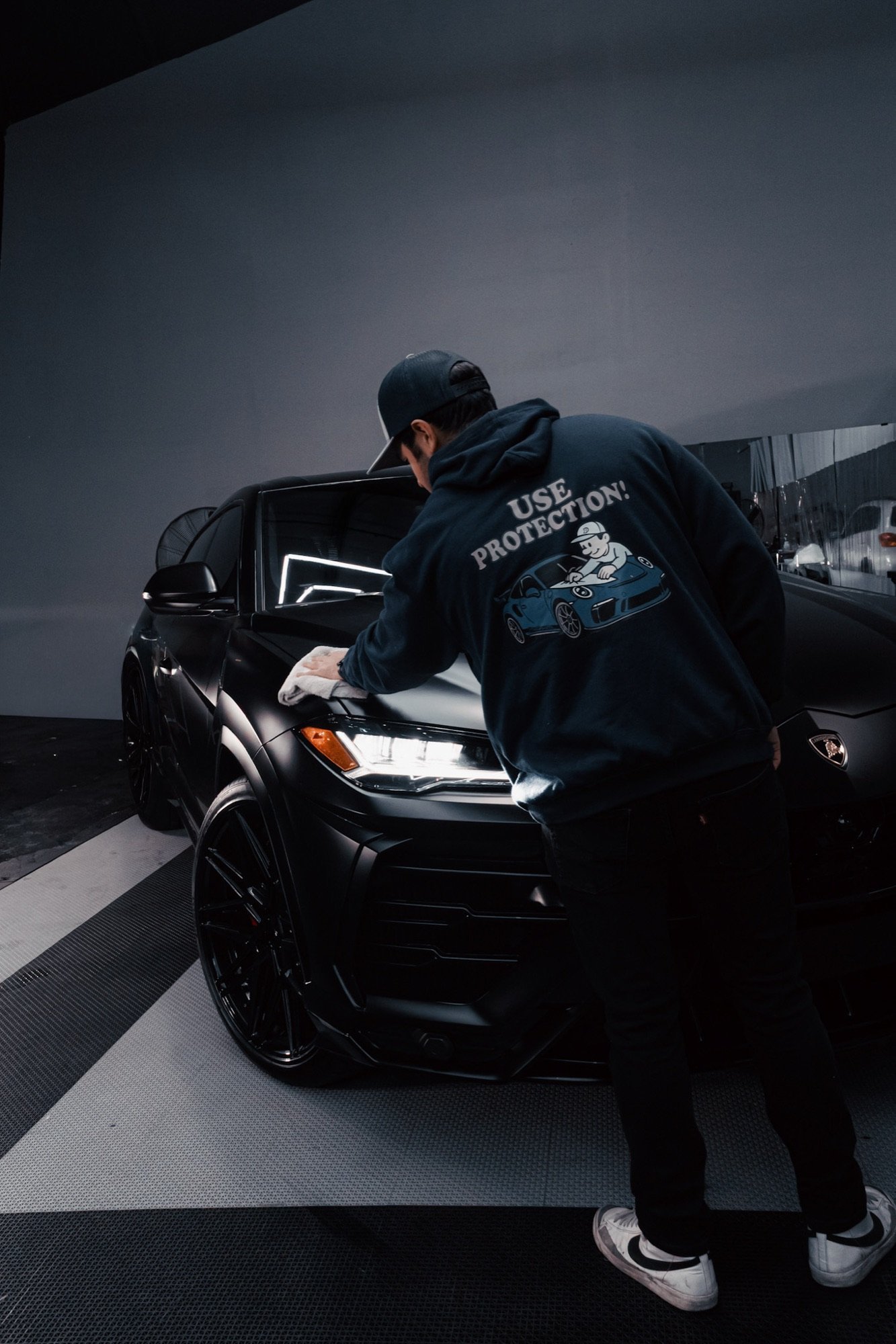 Platinum technician wiping a Lamborghini hood with a microfiber towel