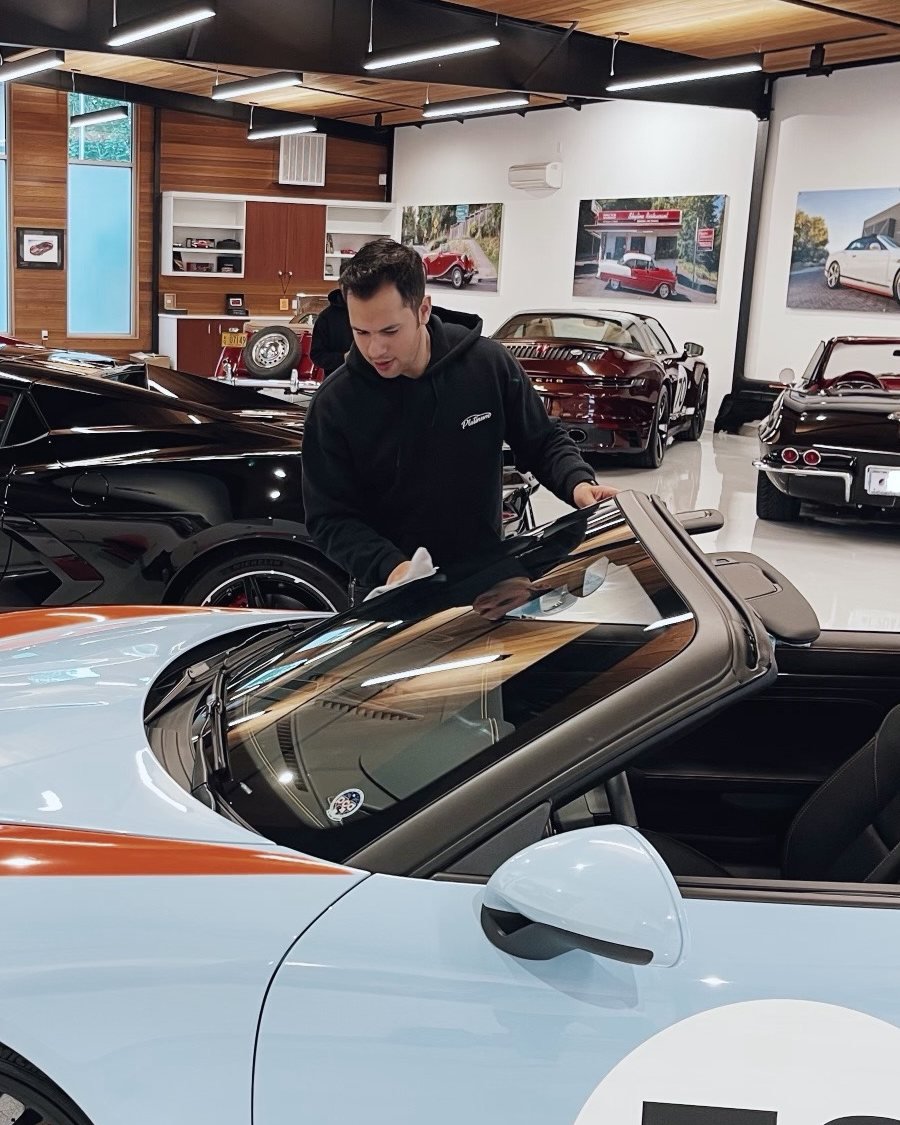 Platinum owner Brayam Sanchez detailing the windshield of a Porsche